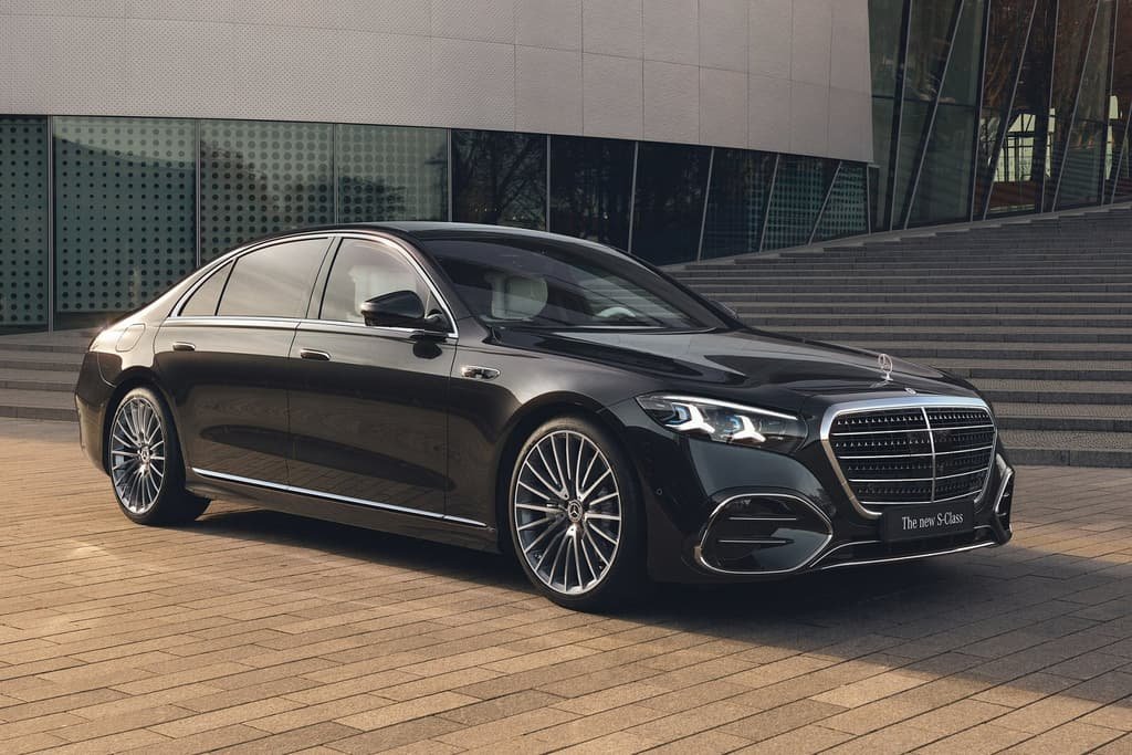 A black Mercedes-Benz S-Class saloon on a paved forecourt