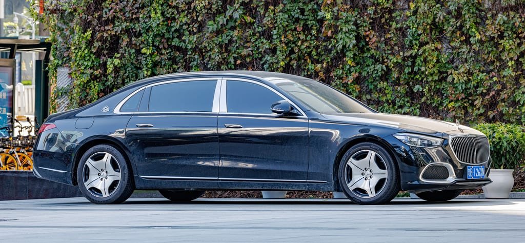 Black Mercedes-Benz S-Class saloon, side view, beside an ivy-covered wall